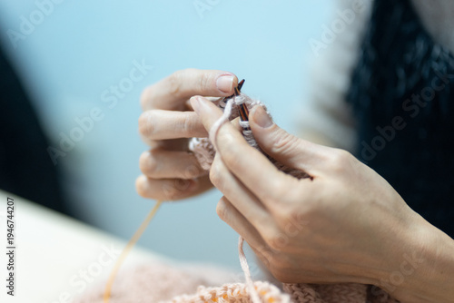 Closeup on female hands with knitting needles and yarn