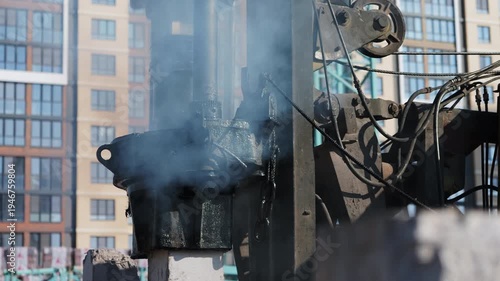 Pile driving machine hammering concrete pile at construction site