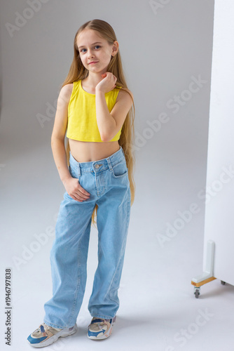 Happy little girl model with long blondie hair. Emotional, cheerful, joyful, cute, adorable caucasin girl posing in studio