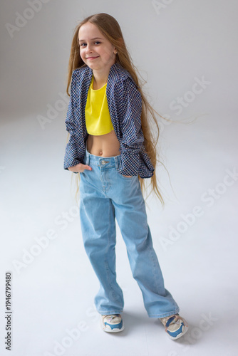 Happy little girl model with long blondie hair. Emotional, cheerful, joyful, cute, adorable caucasin girl posing in studio