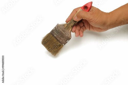 Close up of man's hand holding wall paint brush isolated on white background.Copy space for text.For graphic design,3D rendering and banners