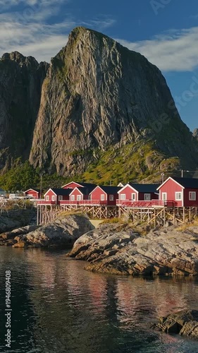 Wallpaper Mural Iconic red fishing cabins in Hamnoy village, vertical aerial view of the stunning Lofoten Islands landscape. Traditional Norwegian rorbuer houses on the rocky coast, Scenic waterfront of Hamnoy Torontodigital.ca