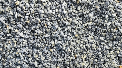 Small stone texture background. Small pieces of hard rocks or granite. close up of gray macadam stones on ground