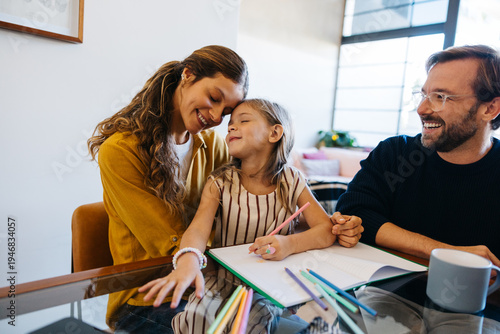 Mother, father and daughter study together at home
