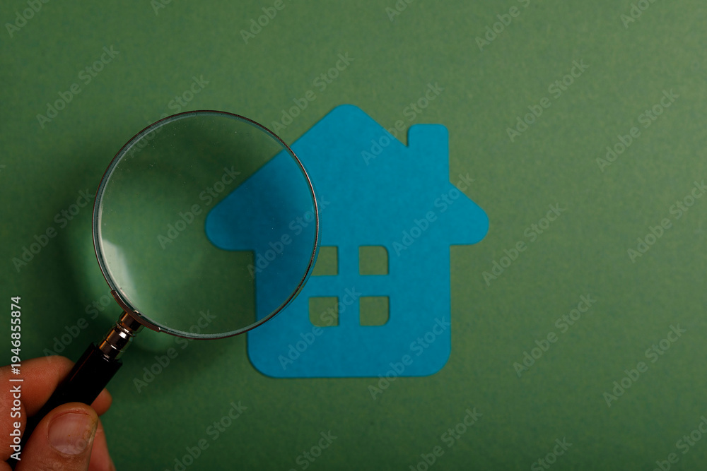 Fototapeta premium Concept of searching for a new home, real estate, and property research. Magnifying glass examining a blue house against