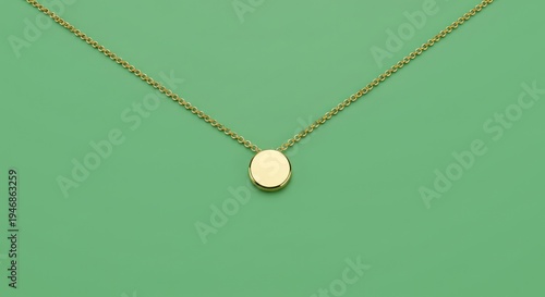 Elegant gold necklace with circular pendant on a vibrant green background for fashion accessory