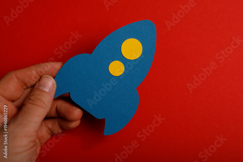 A hand holding a blue paper...