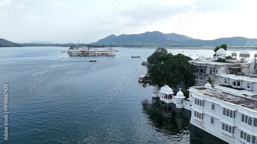 Aerial View of Peaceful Lake with Historic White Buildings and Mountains