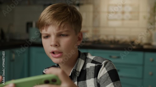 Emotional Boy Playing Mobile Game on Smartphone