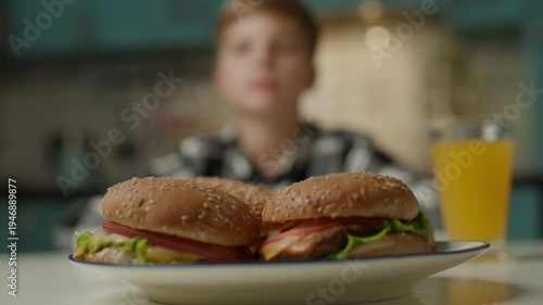 Boy Licking Lips with Tasty Burgers in Front