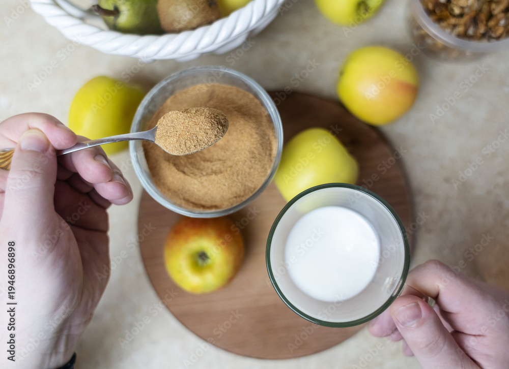 custom made wallpaper toronto digitalPerson adding apple fiber powder to a glass of yogurt, surrounded by fresh apples and walnuts. Healthy prebiotic supplement for gut health, digestion and weight management.