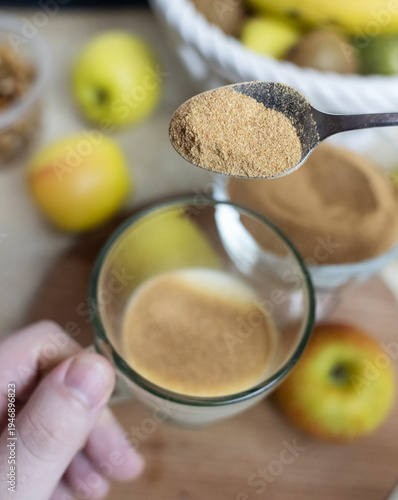 Wallpaper Mural Person adding apple fiber powder to a glass of yogurt, surrounded by fresh apples and walnuts. Healthy prebiotic supplement for gut health, digestion and weight management. Torontodigital.ca