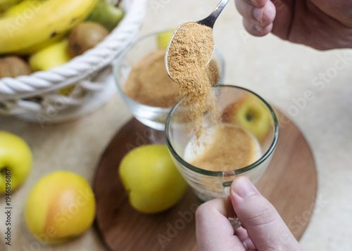 Wallpaper Mural Person adding apple fiber powder to a glass of yogurt, surrounded by fresh apples and walnuts. Healthy prebiotic supplement for gut health, digestion and weight management. Torontodigital.ca