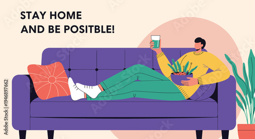 Relaxed man lies on a purple sofa at home while eating a healthy salad and drinking a glass of juice in a peaceful environment.