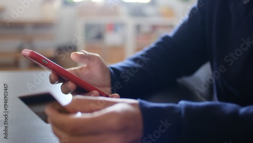 Konstfotografi Person holding a mobile phone and credit card, using online banking application