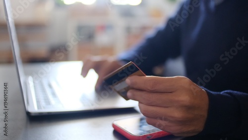 Fotografi Person making a secure digital payment online, holding a credit card while typin