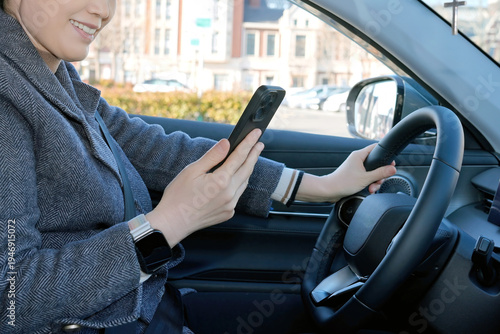Woman driving car while using smartphone