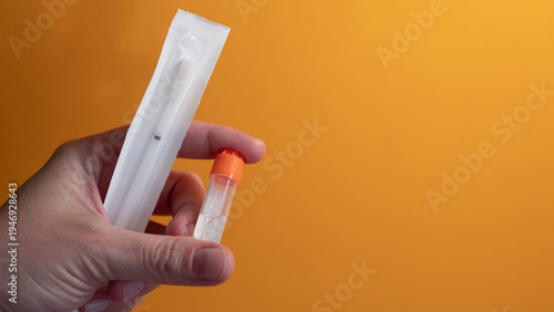 Photos Hand holding home DNA testing kit with saliva sample tube for genetic ancestry t