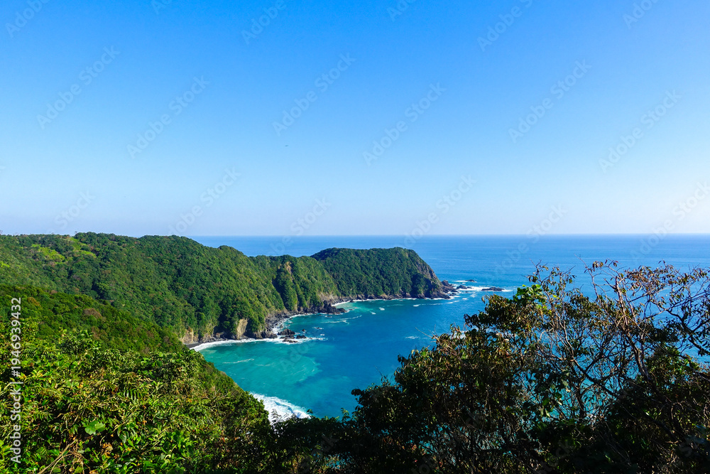 Fototapeta premium Turquoise coastal bay and forested cliffs along Shikoku Henro pilgrimage trail in Shikoku Japan