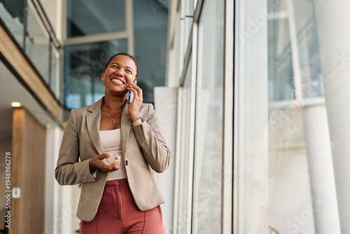 Portrait of a smart young businesswoman using a smartphone phone and making a call in the office. Startup and succesful business concept