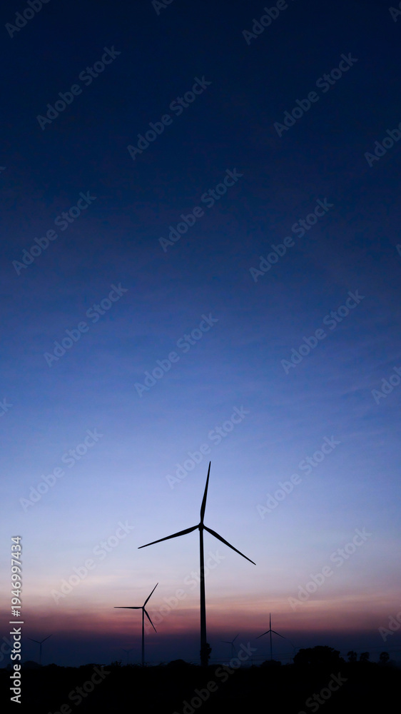 Obraz premium Renewable Energy Wind Turbine Landscape with Sunset Sky Backgrou