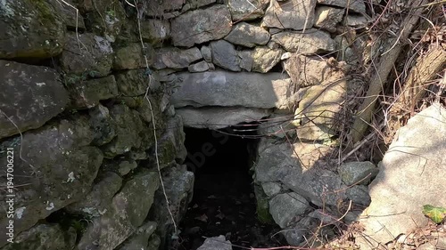 Natural spring water source in old stone structure in forest