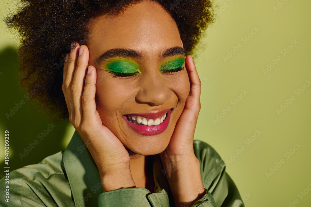 Naklejka premium Beautiful woman embraces joyful moments with vibrant green makeup and a chic outfit