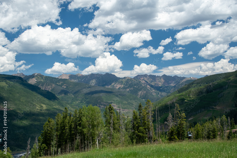 Fototapeta premium Wide Rocky Mountain Valley Landscape Under Blue Sky with Clouds, Vail Colorado