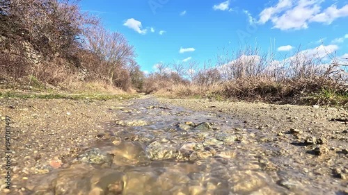 Low angle view of small stream flowing along countryside path