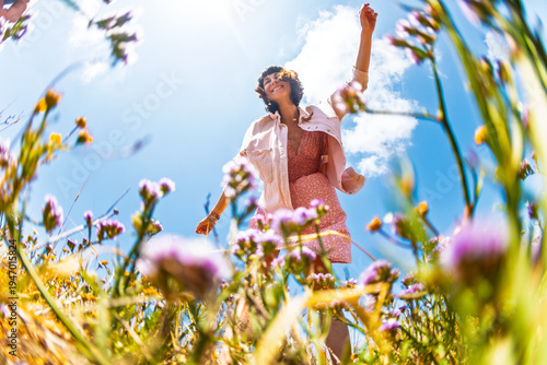 Summer lifestyle portrait of a beautiful young brunette in a summer pink dress. Romantic mood.