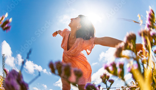 Summer lifestyle portrait of a beautiful young brunette in a summer pink dress. Romantic mood.