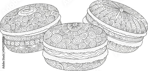 Three detailed, black and white, patterned macarons on a white background, with intricate, swirling designs