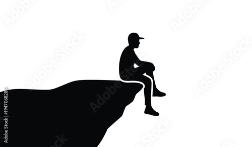 A silhouette of a lonely person wearing a cap sitting on the edge of a high cliff looking forward