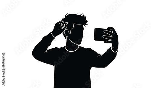 A silhouette of a young man with styled hair posing while taking a selfie with his mobile phone