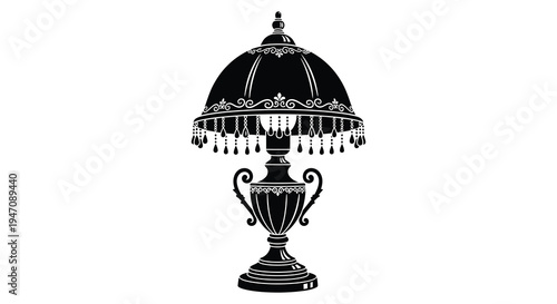An ornate decorative table lamp with a fringed shade is presented in a stark black silhouette high quality