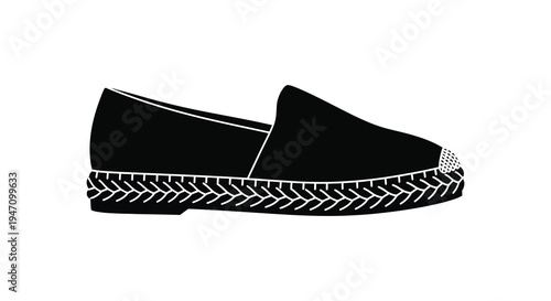 A black espadrille shoe is displayed in a side profile showcasing its woven sole and sleek design silhouette