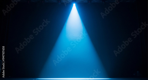 Bright blue spotlight shining down on a dark stage.