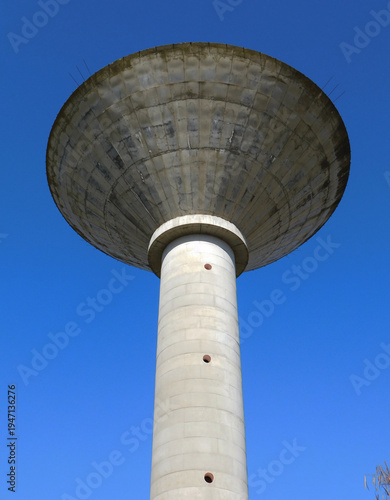 Tall Concrete Water Tower Against a Clear Blue Sky