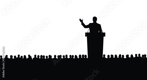 Speaker addressing a large audience a stark black silhouette