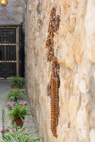 Catholic Rosary Hanging on Stone Wall in Holy Land