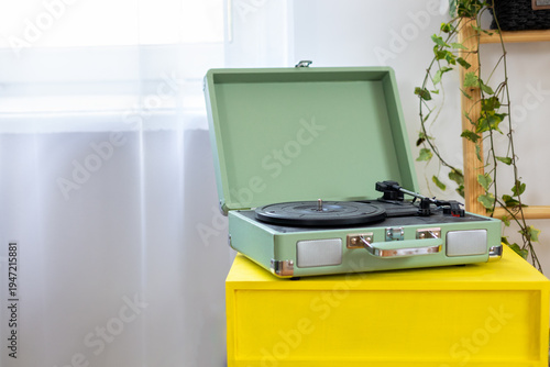Wallpaper Mural Vintage green record player with vinyl record on yellow table in a modern cozy interior with houseplants. Stylish retro music concept, home decor, analog sound and nostalgia lifestyle with copy space. Torontodigital.ca