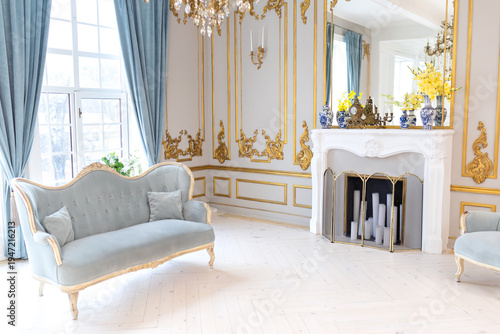 Wallpaper Mural classic interior with elegant armchairs, decorative fireplace and crystal chandelier. Bright palace style living room with blue velvet furniture, gold wall ornaments and large windows at home Torontodigital.ca