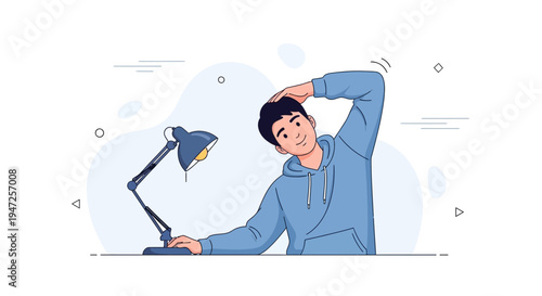 Young man stretching neck while working at desk with lamp