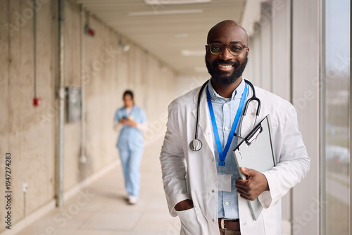 Canvas Print Happy black medical expert working in a hospital and looking at camera