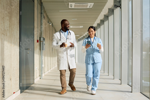 Tableau sur toile Happy black doctor and nurse having a coffee break at medical clinic
