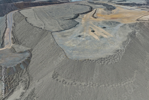 Aerial view of enormous mine waste dumps filled with benches
