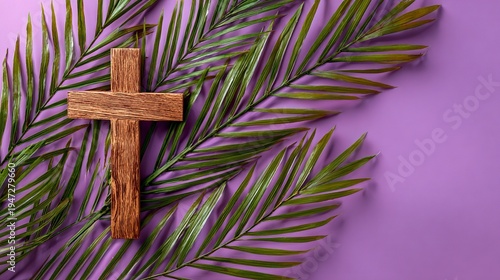 A wooden cross lies on a palm leaf against a purple background symbolizing faith and spirituality.