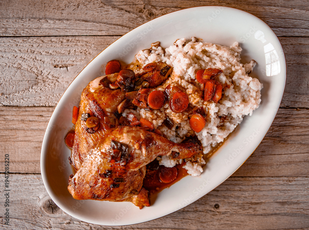 Naklejka premium Roasted chicken drumsticks served with steamed rice and fresh vegetable salad on a plate