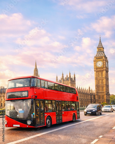 Obraz na płótnie A red double-decker bus is driving down a street in London