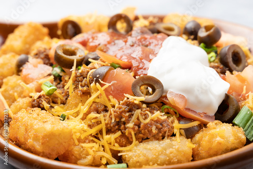 Loaded tater tot nachos with ground beef cheese and sour cream